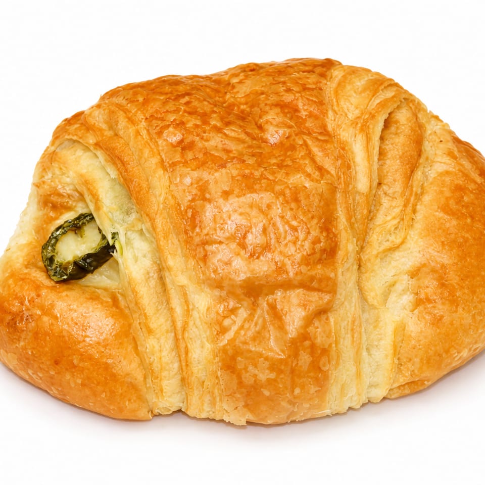 Golden-brown croissant with a savory green filling, likely spinach or jalapeño, on a white background.